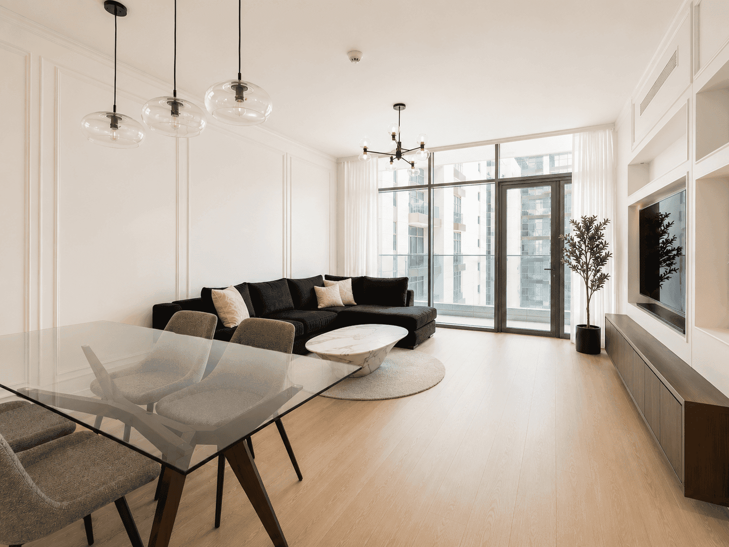 Open-plan living room renovation with glass dining table, pendant lights and balcony access in Park Heights apartment