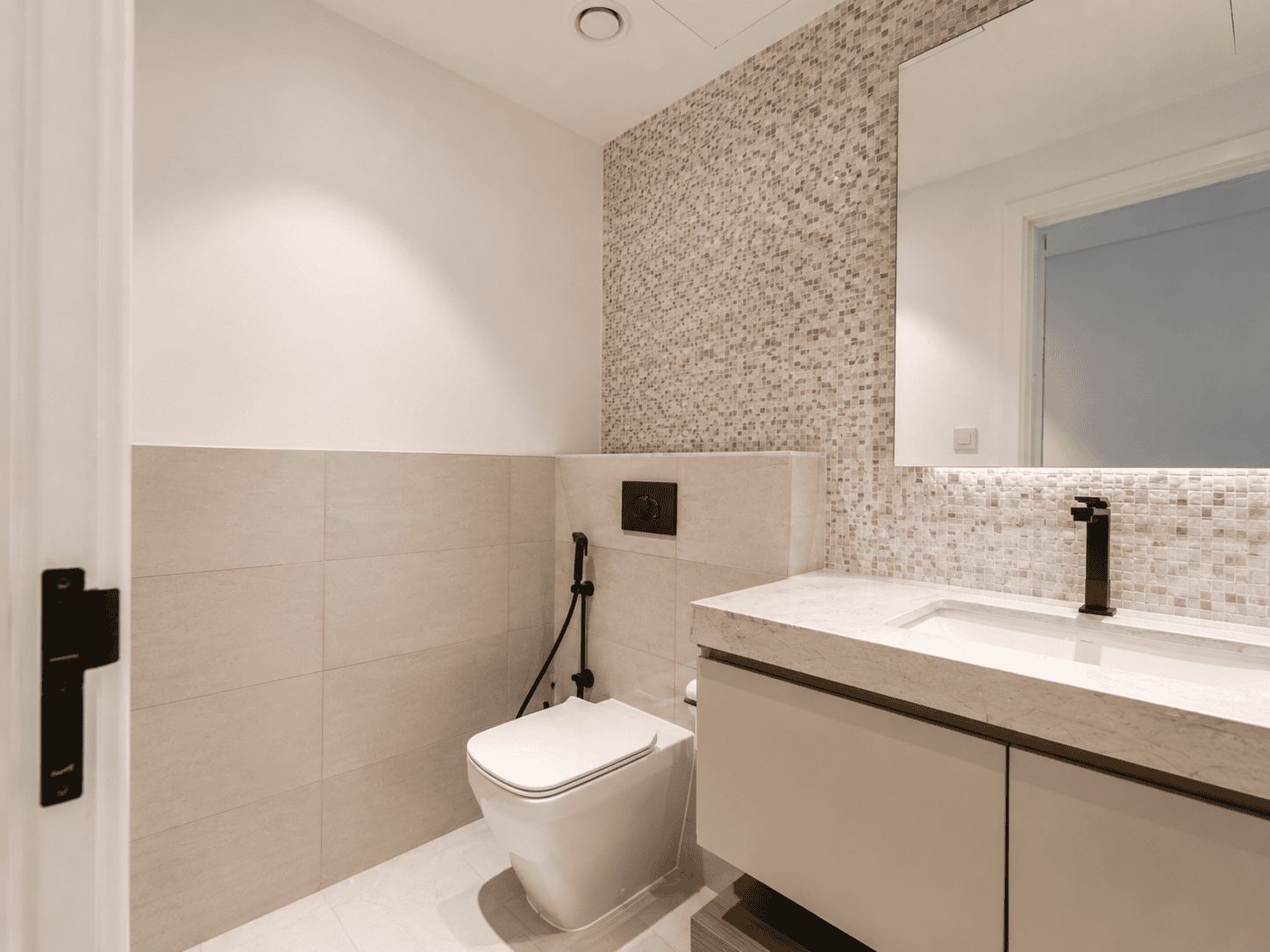 Guest powder room renovation with mosaic accent wall, marble counter and matte black tap in Dubai Hills Estate