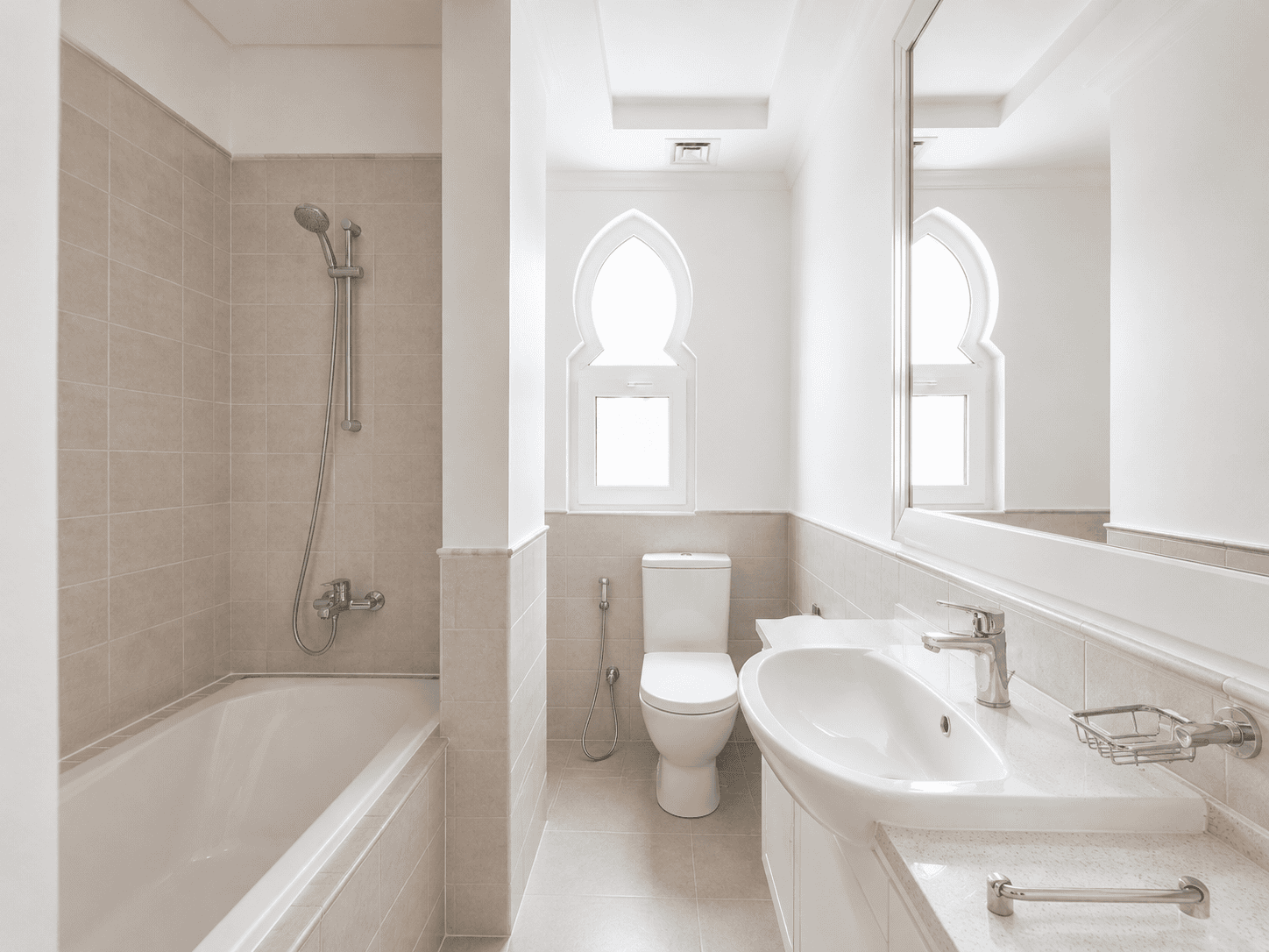 Bathroom renovation with bathtub, arched Moorish window and twin vanities in Victory Heights villa, Dubai