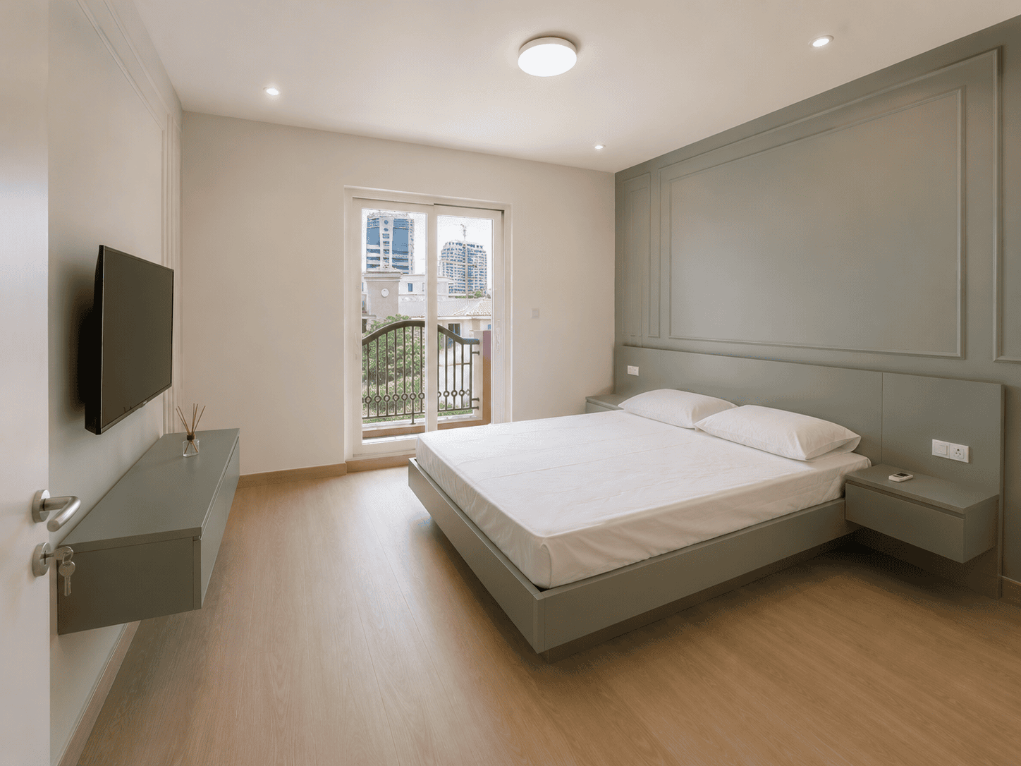 Bedroom renovation with sage green panelled feature wall, floating bed and balcony in Victory Heights villa, Dubai