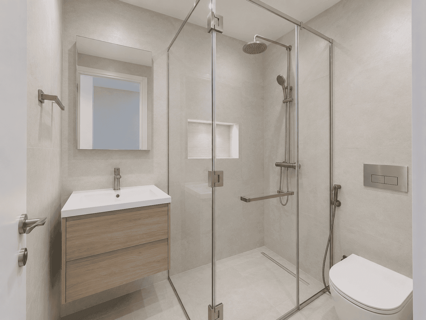 En-suite bathroom renovation with frameless glass shower cube, wall-hung toilet and floating vanity in Lakes villa