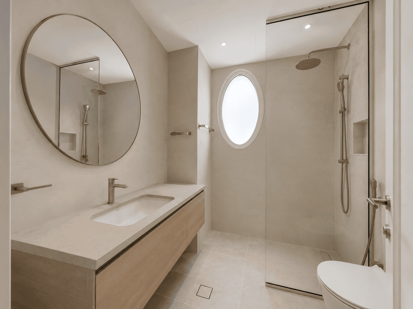 Common bathroom renovation with round mirror, oak vanity and walk-in shower in The Lakes villa, Dubai