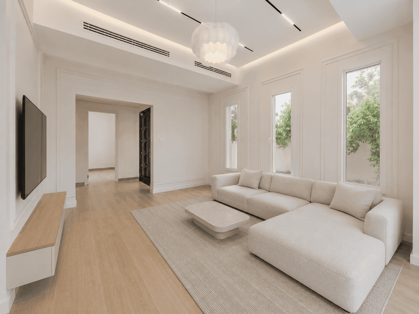 Family hall renovation with wall-mounted TV, pendant light and tall garden windows in The Lakes villa, Dubai