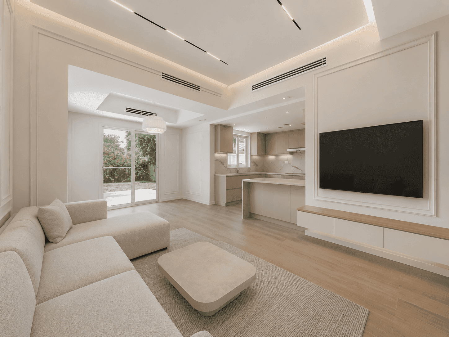 Renovated open-plan hall and kitchen with cove lighting, TV wall and garden access in The Lakes villa, Dubai