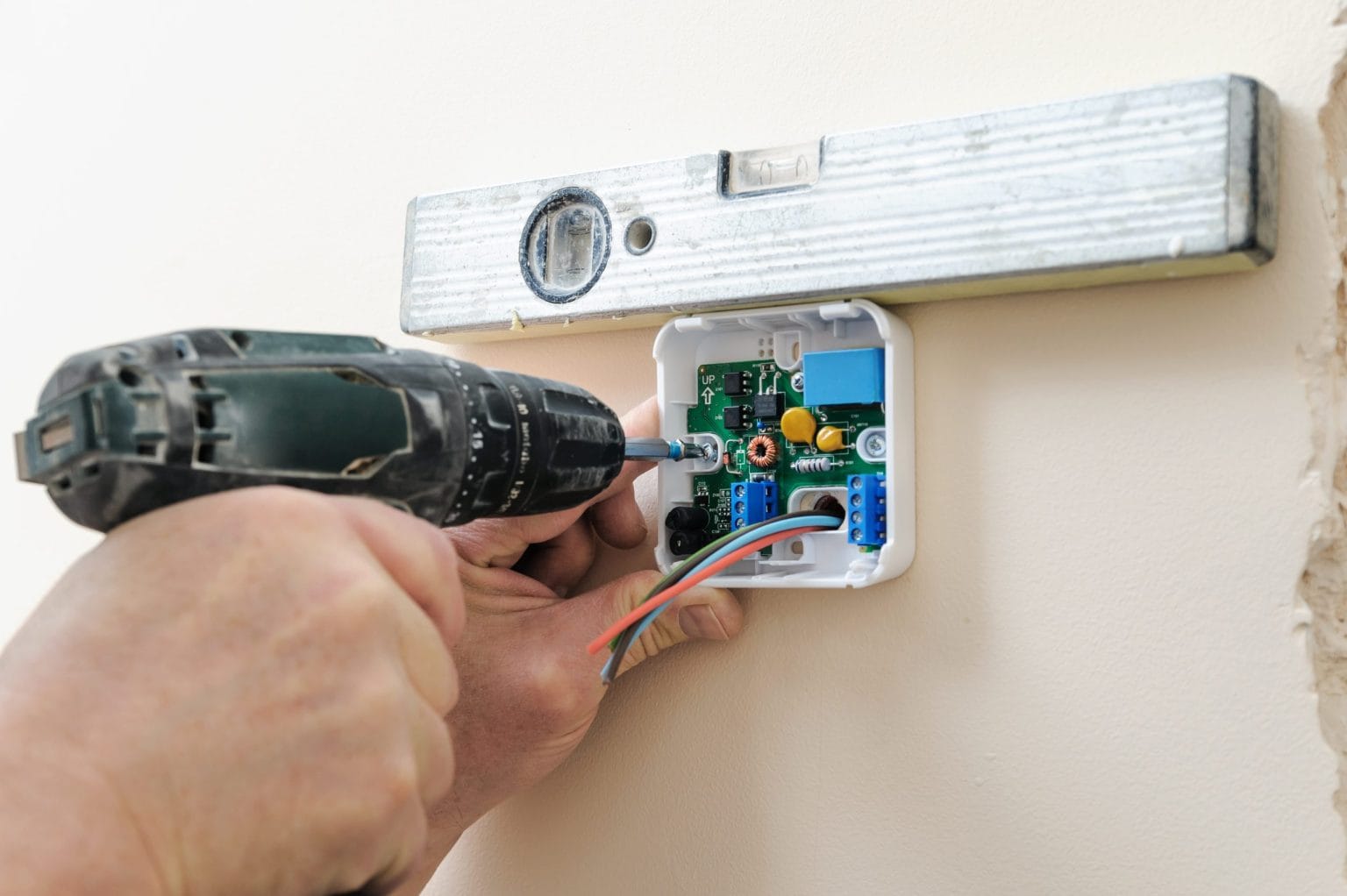 Fixing a thermostat back plate to a wall with a drill driver