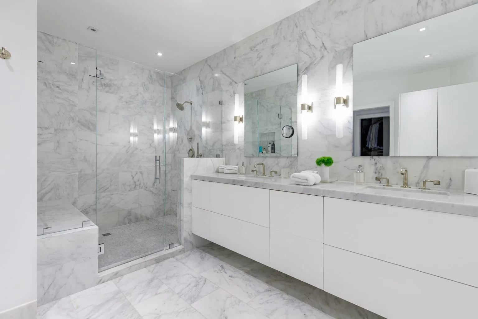 Bathroom renovation and remodeling in Dubai with a Carrara marble frameless glass shower and floating double vanity by Abdulla Carpentry EST