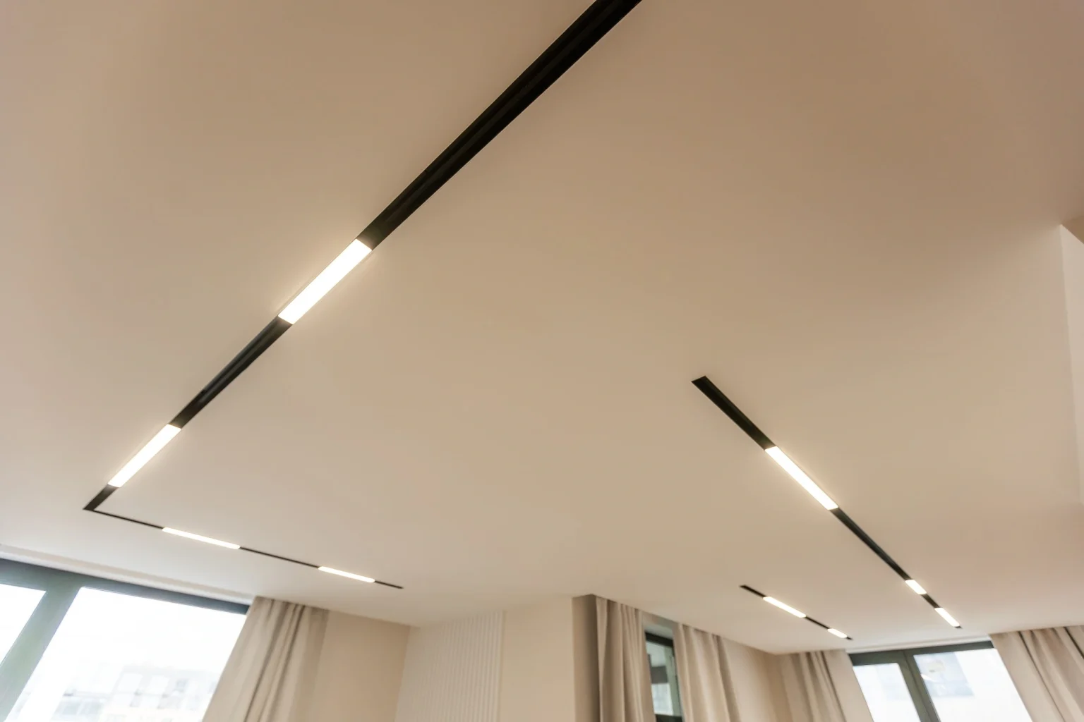 Minimalist false ceiling with recessed linear LED track lighting in a Dubai apartment