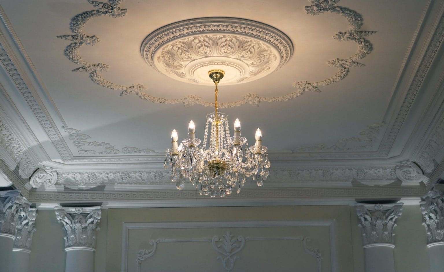 Chandelier hung from a decorative ceiling rose in a Dubai interior