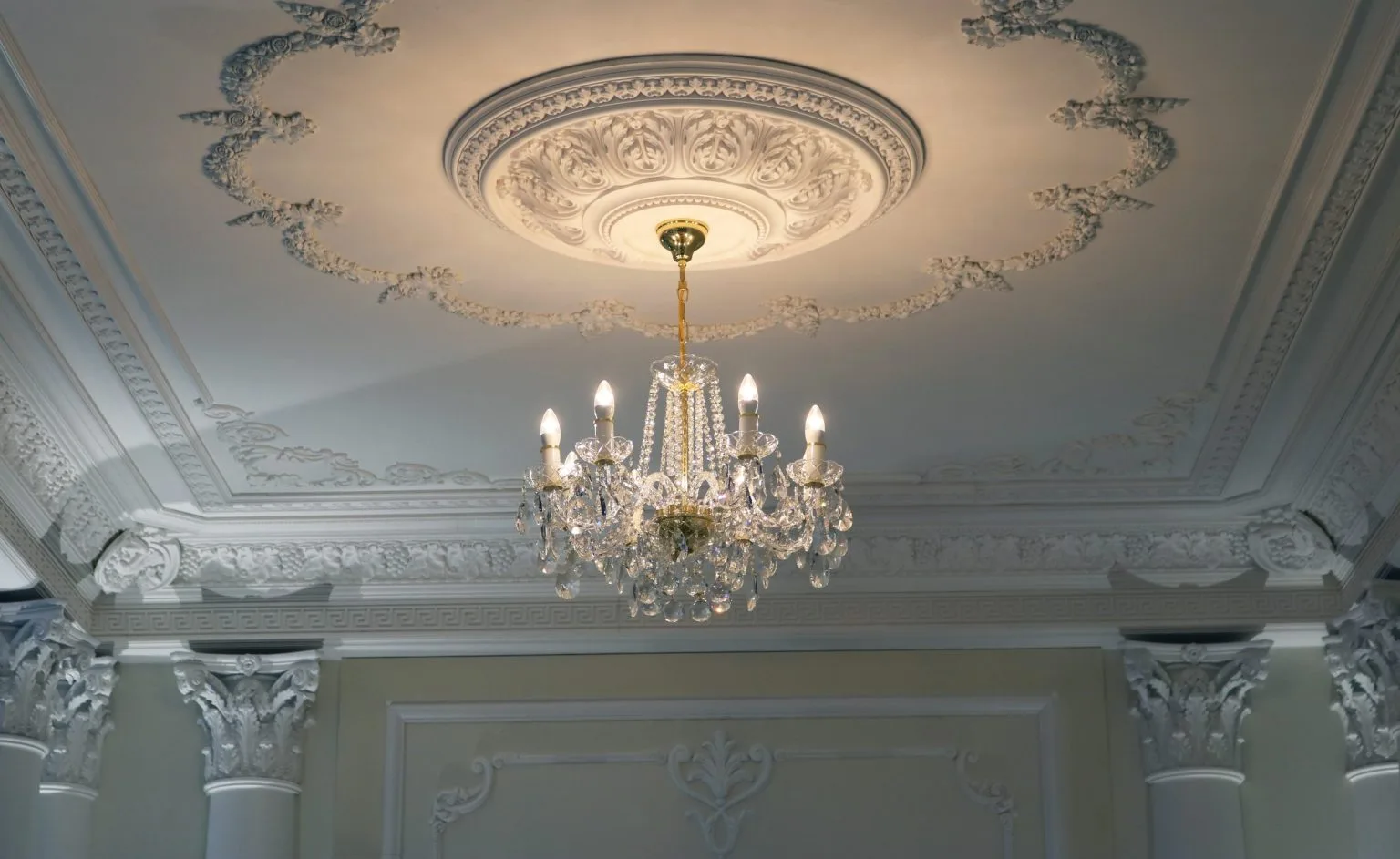 Chandelier hung from an ornate ceiling rose after lighting installation in a Dubai villa