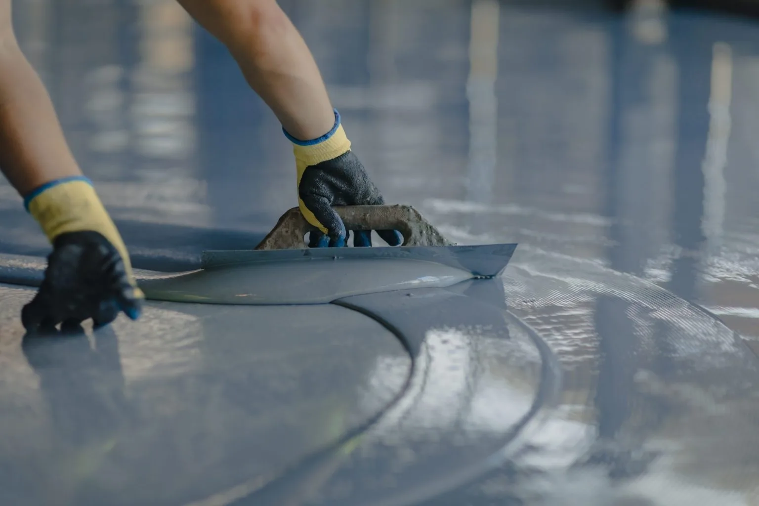 Self-levelling compound trowelled out to level a floor screed before finishes