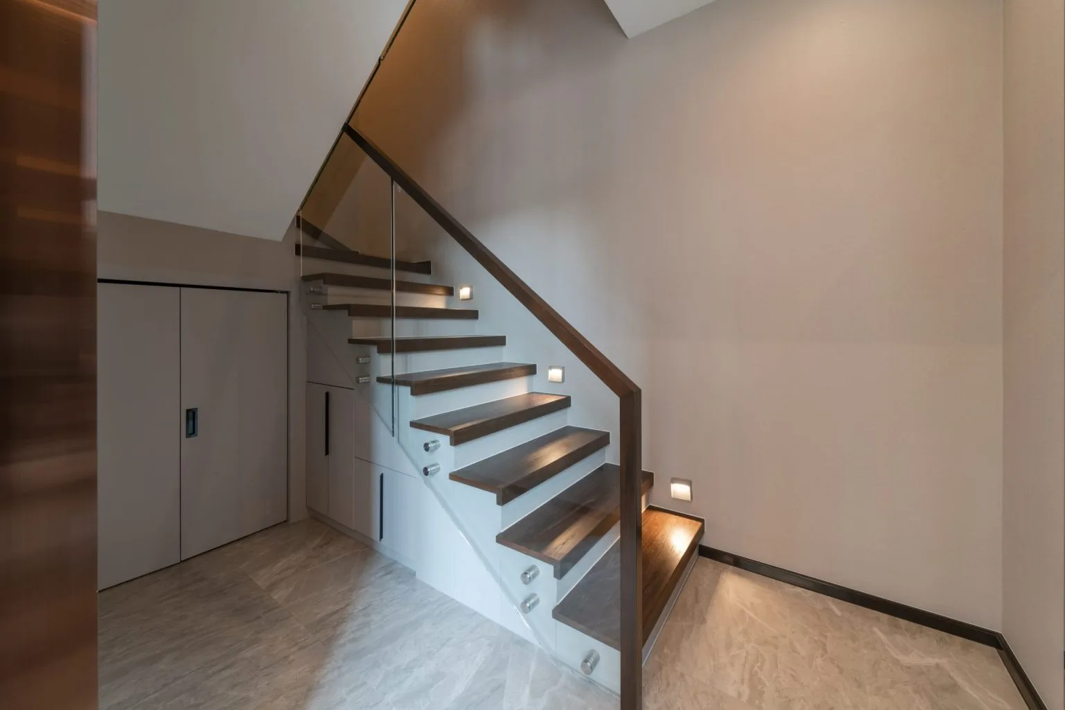 Timber staircase with a frameless glass balustrade in a Dubai villa