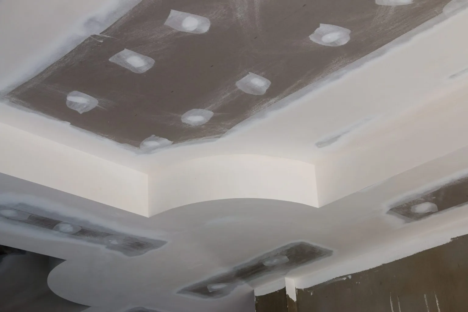 Curved gypsum bulkhead with recessed spotlights in a Dubai interior