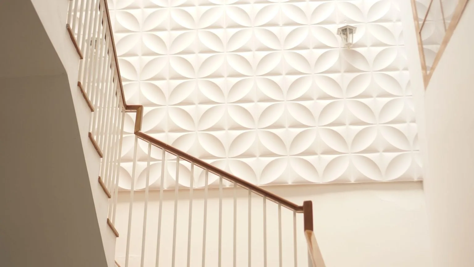 Three-dimensional gypsum wall cladding running up a staircase wall in Dubai