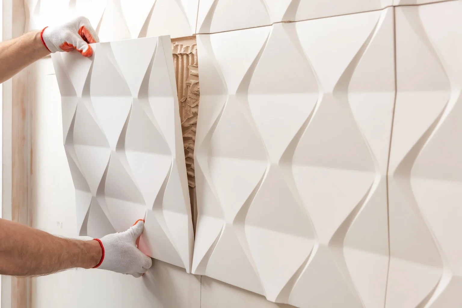 Installer fixing a three-dimensional decorative gypsum wall panel in Dubai