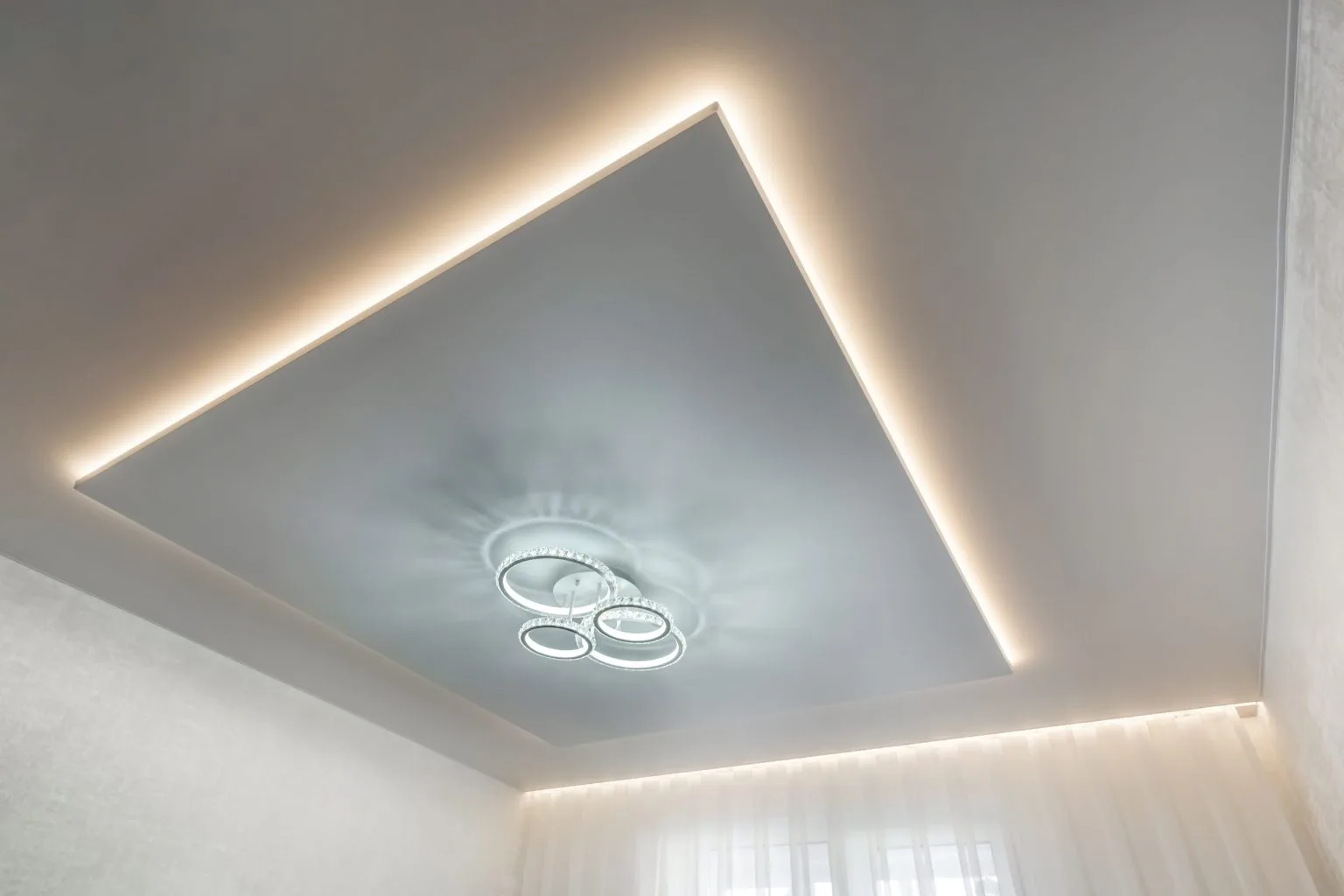 Gypsum works in Dubai: a multi-level gypsum tray ceiling with concealed LED cove lighting and a feature pendant