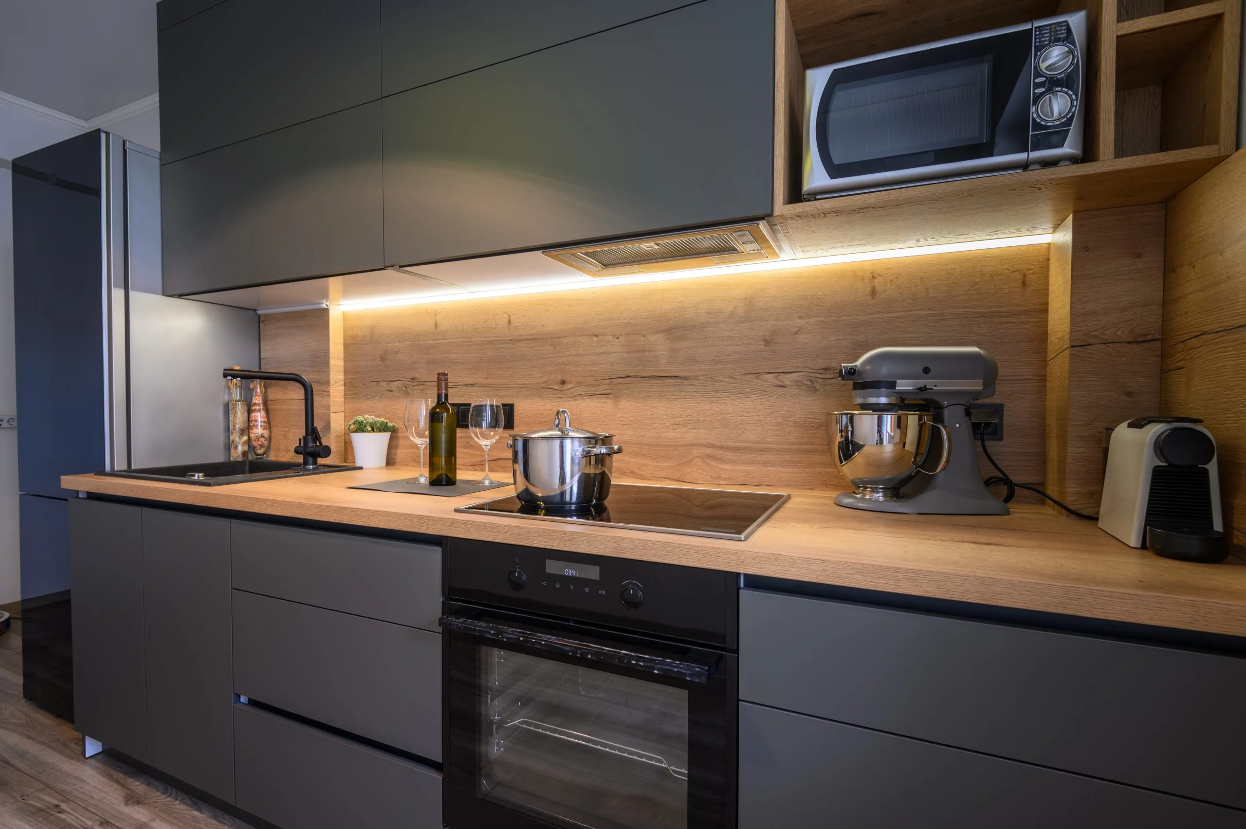 Under-cabinet kitchen lighting over a wood-effect worktop, fitted during a kitchen fit out in Dubai