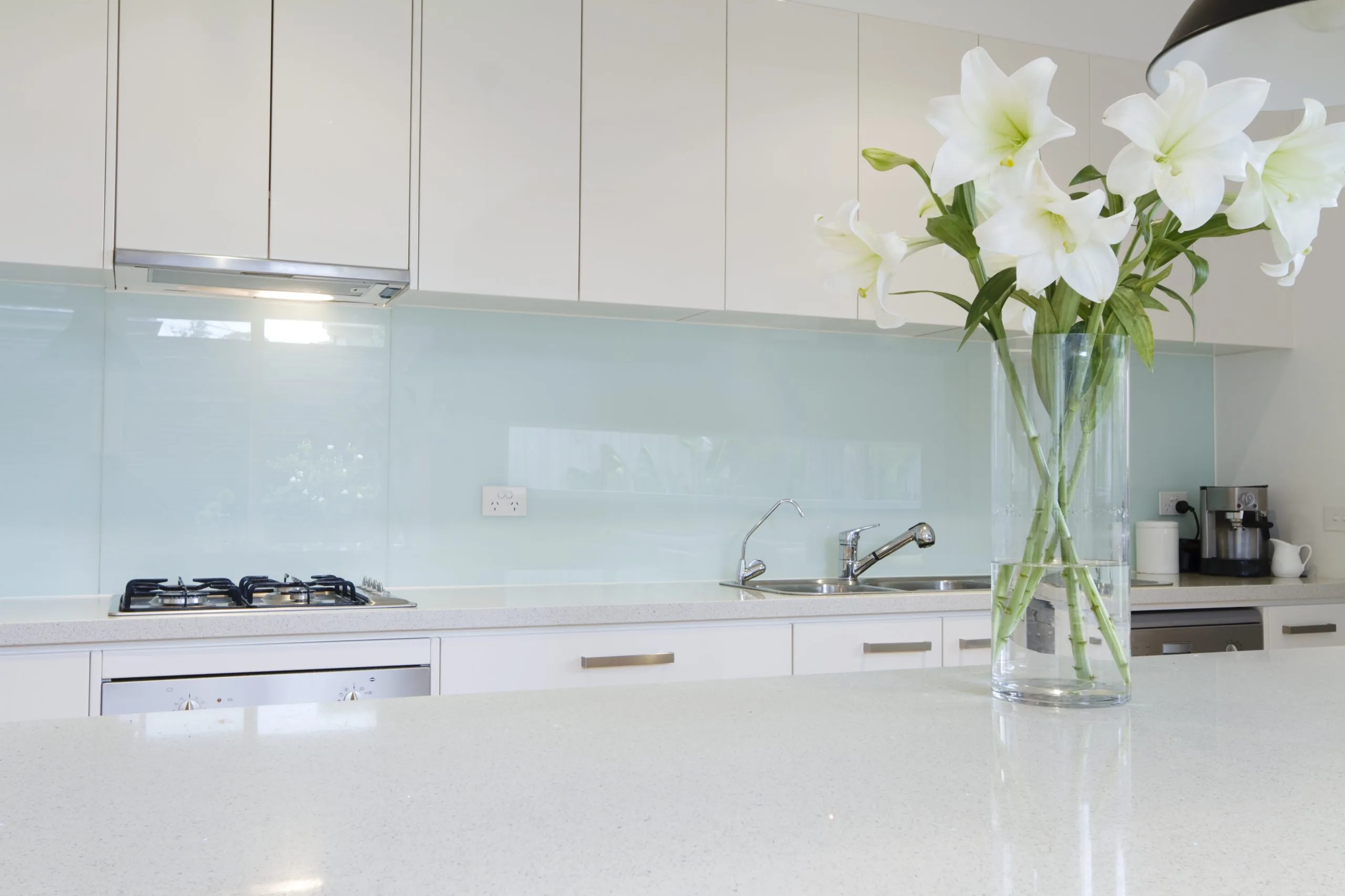 Kitchen backsplash in back-painted glass above a quartz countertop in a Dubai kitchen makeover