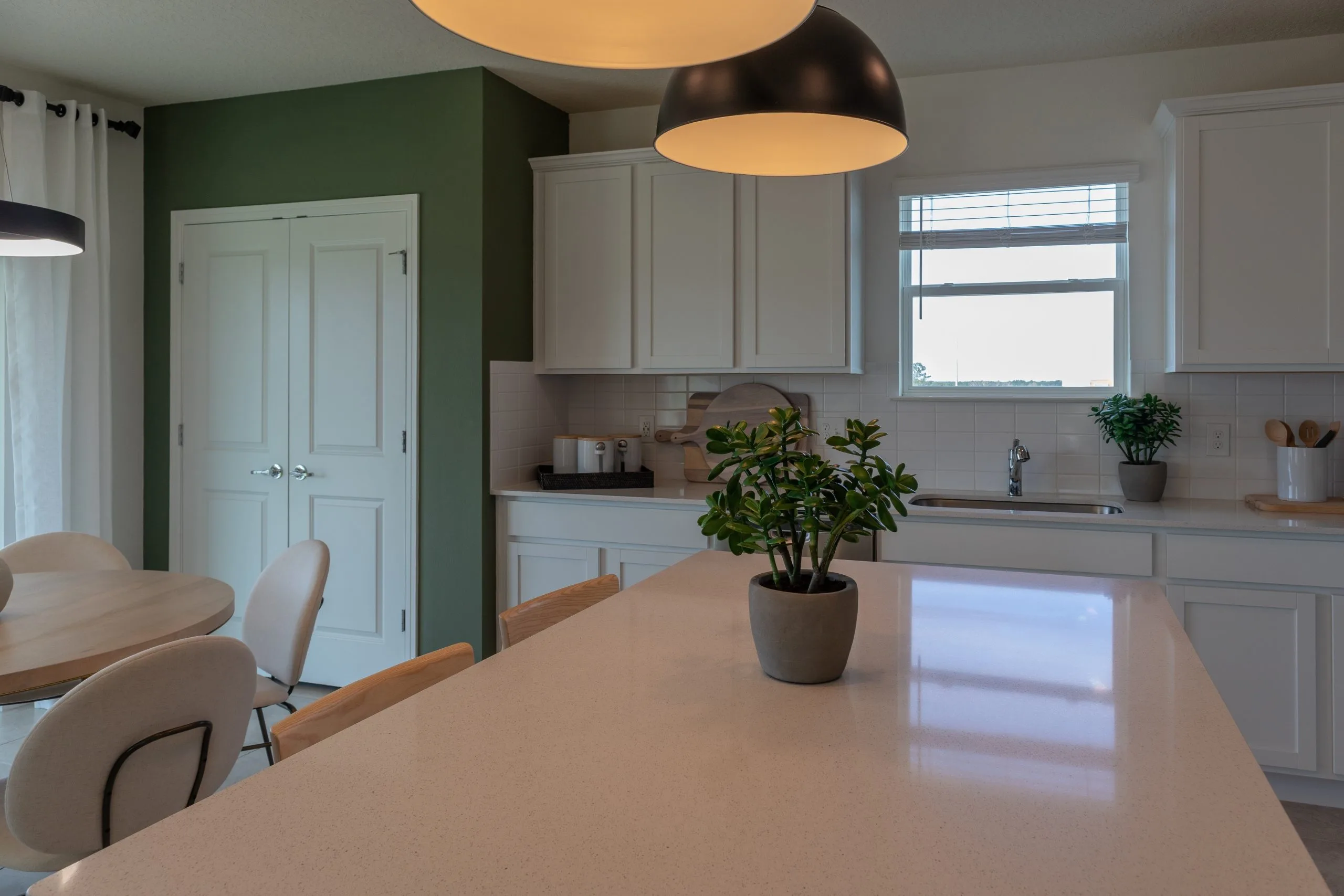 Bright apartment kitchen renovation in Dubai with a quartz island and painted feature wall