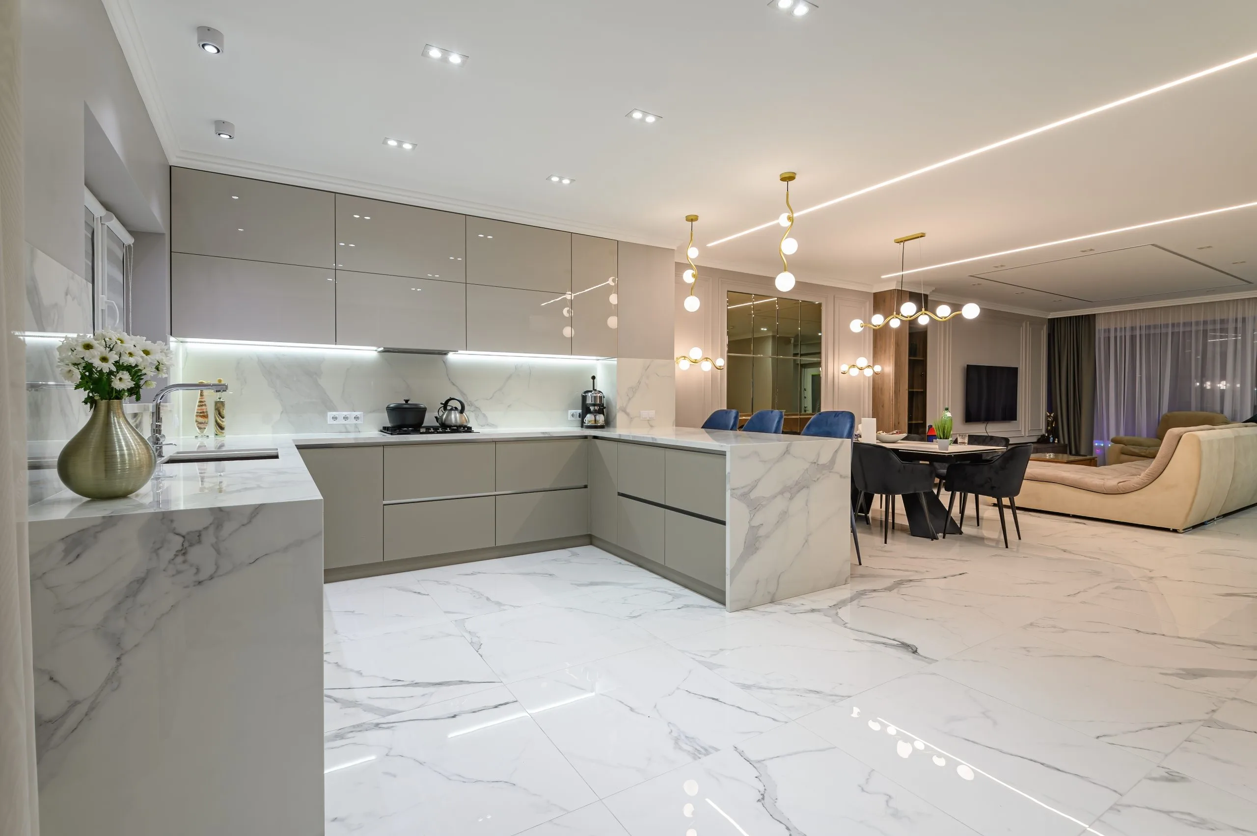 Open kitchen conversion in Dubai with gloss cabinets flowing into a marble-floored dining area