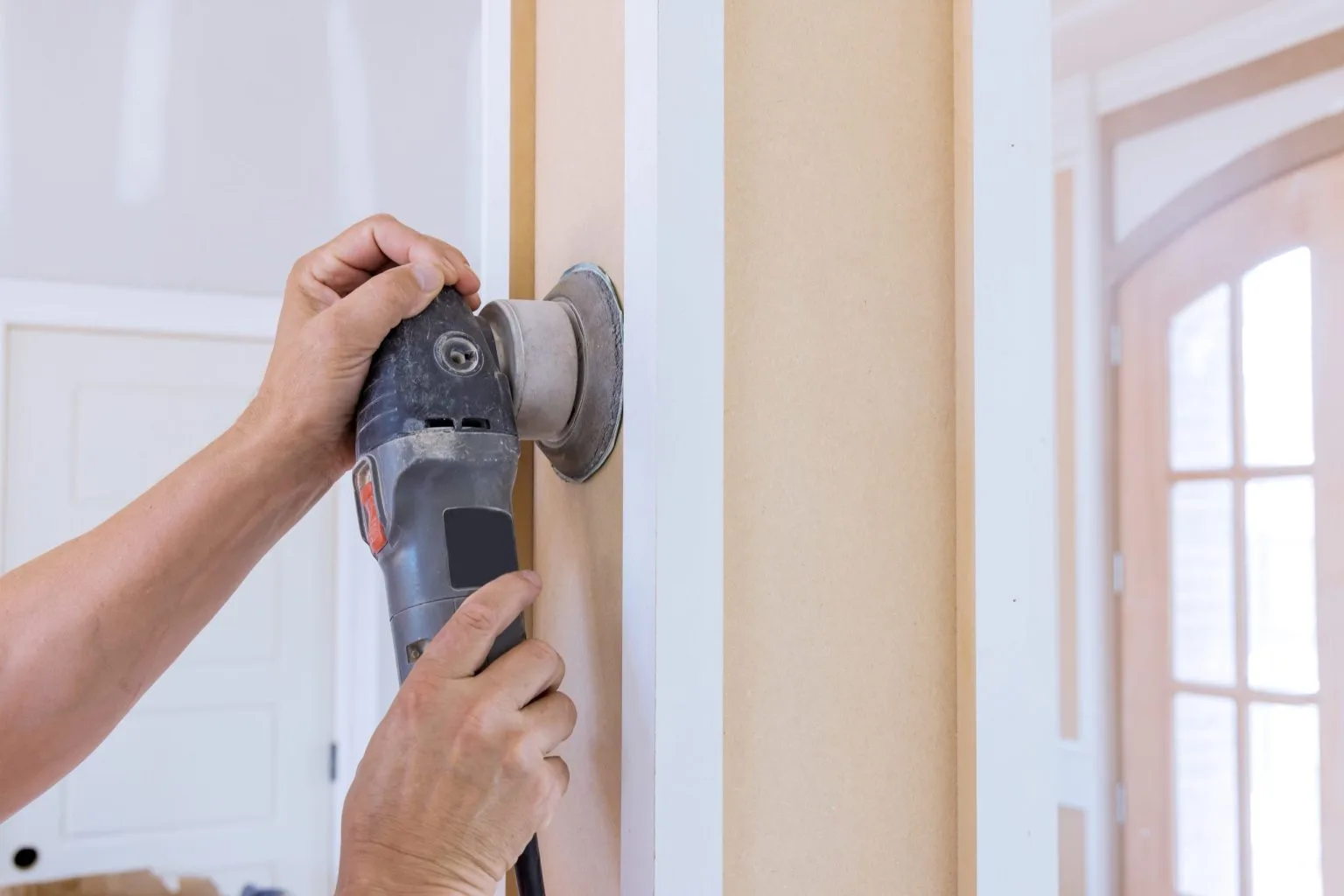 Power sander smoothing MDF panelling ahead of primer on a Dubai painting job