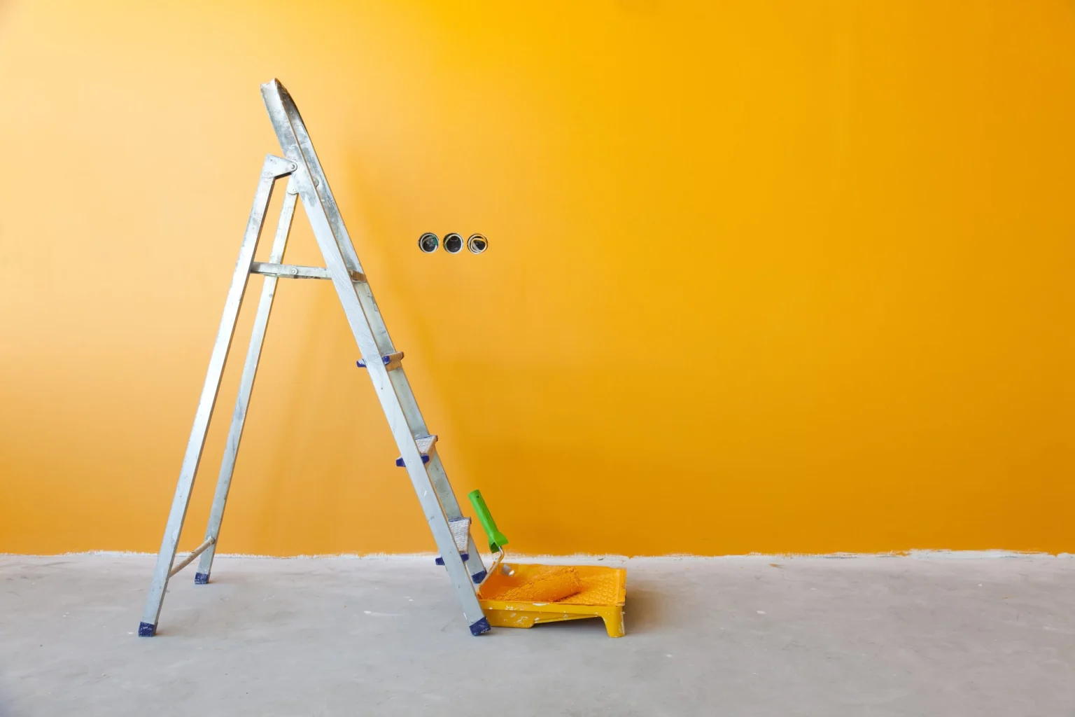 Painting services in Dubai &mdash; roller, tray and ladder against a freshly coated wall on an Abdulla Carpentry EST site
