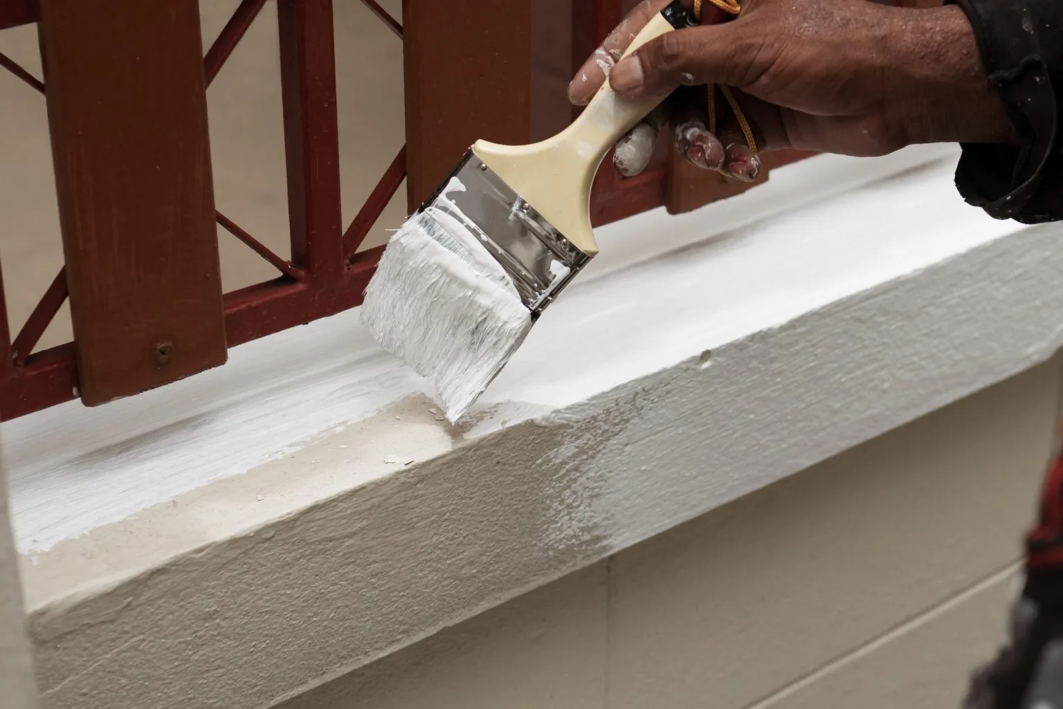 Painter cutting in a clean white line along a window frame during interior painting in Dubai