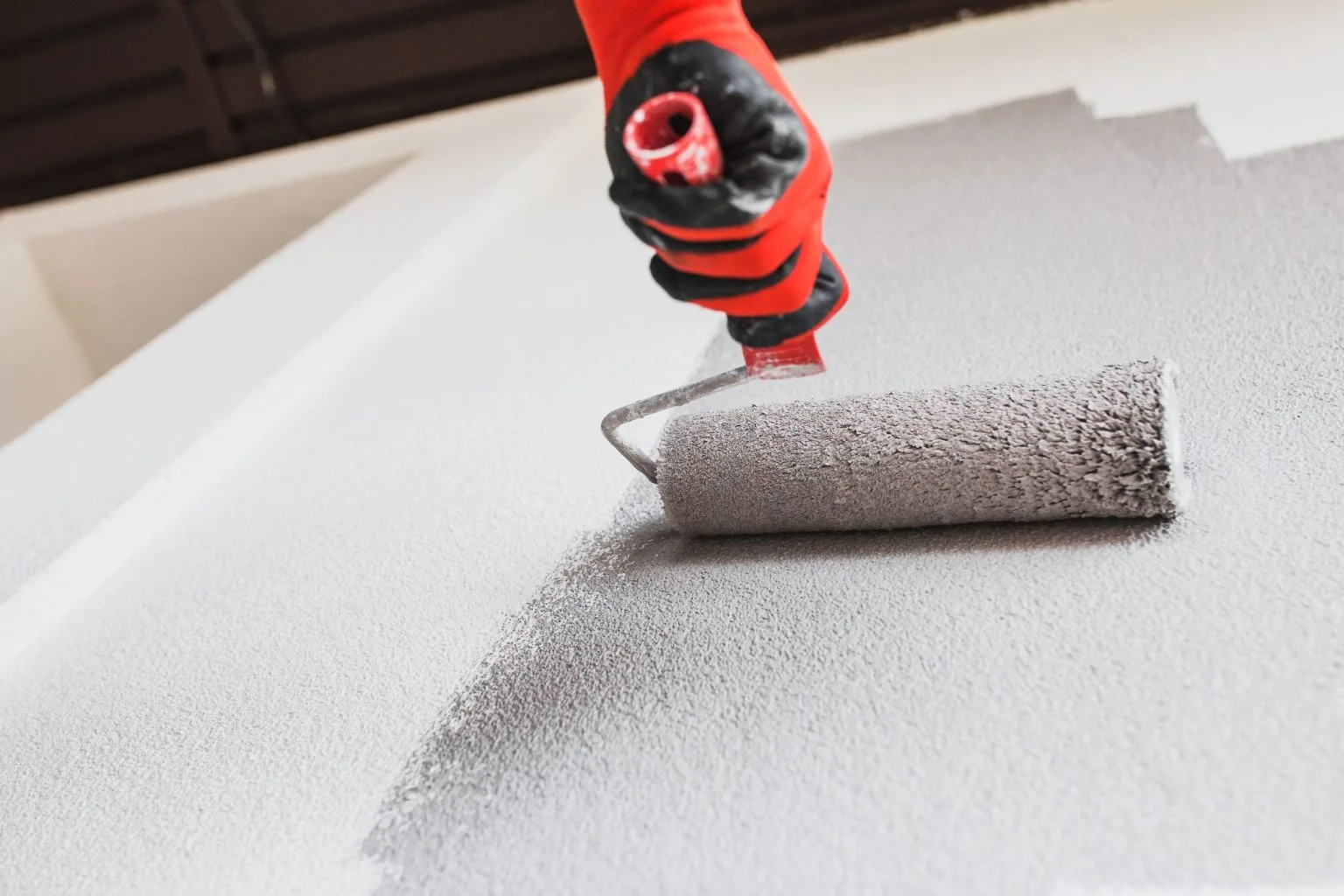 Protective coating being rolled over a prepared surface during painting works in Dubai