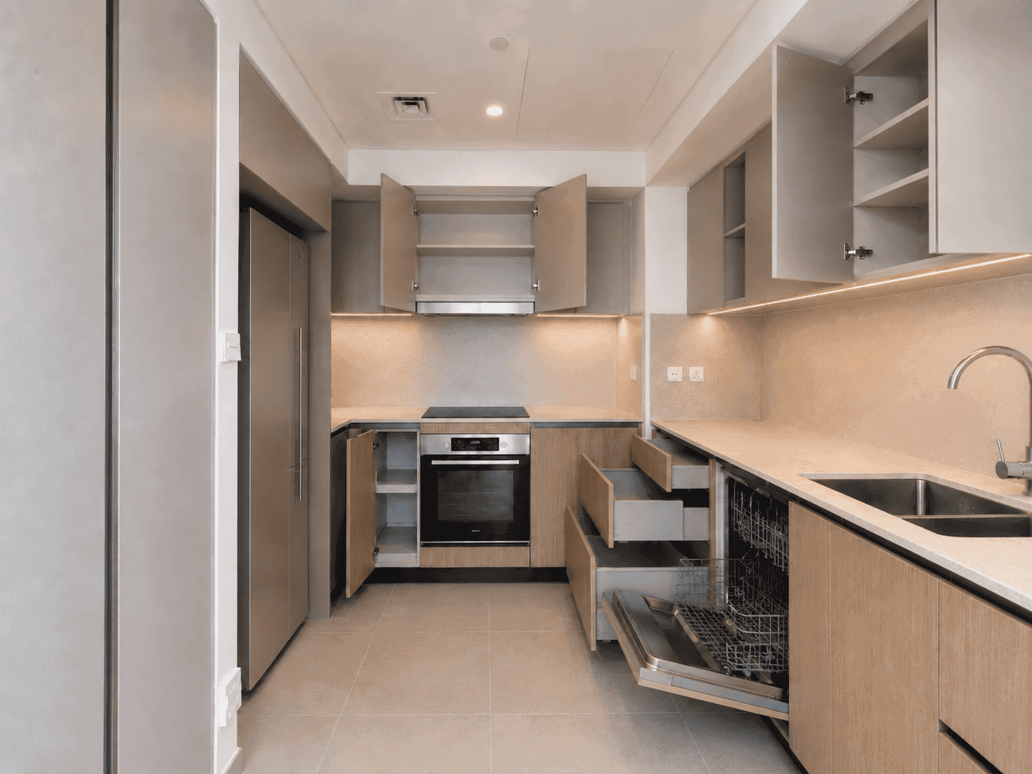 Kitchen with integrated appliances, soft-close drawers, dishwasher and full-height fridge housing in Creek Harbour apartment