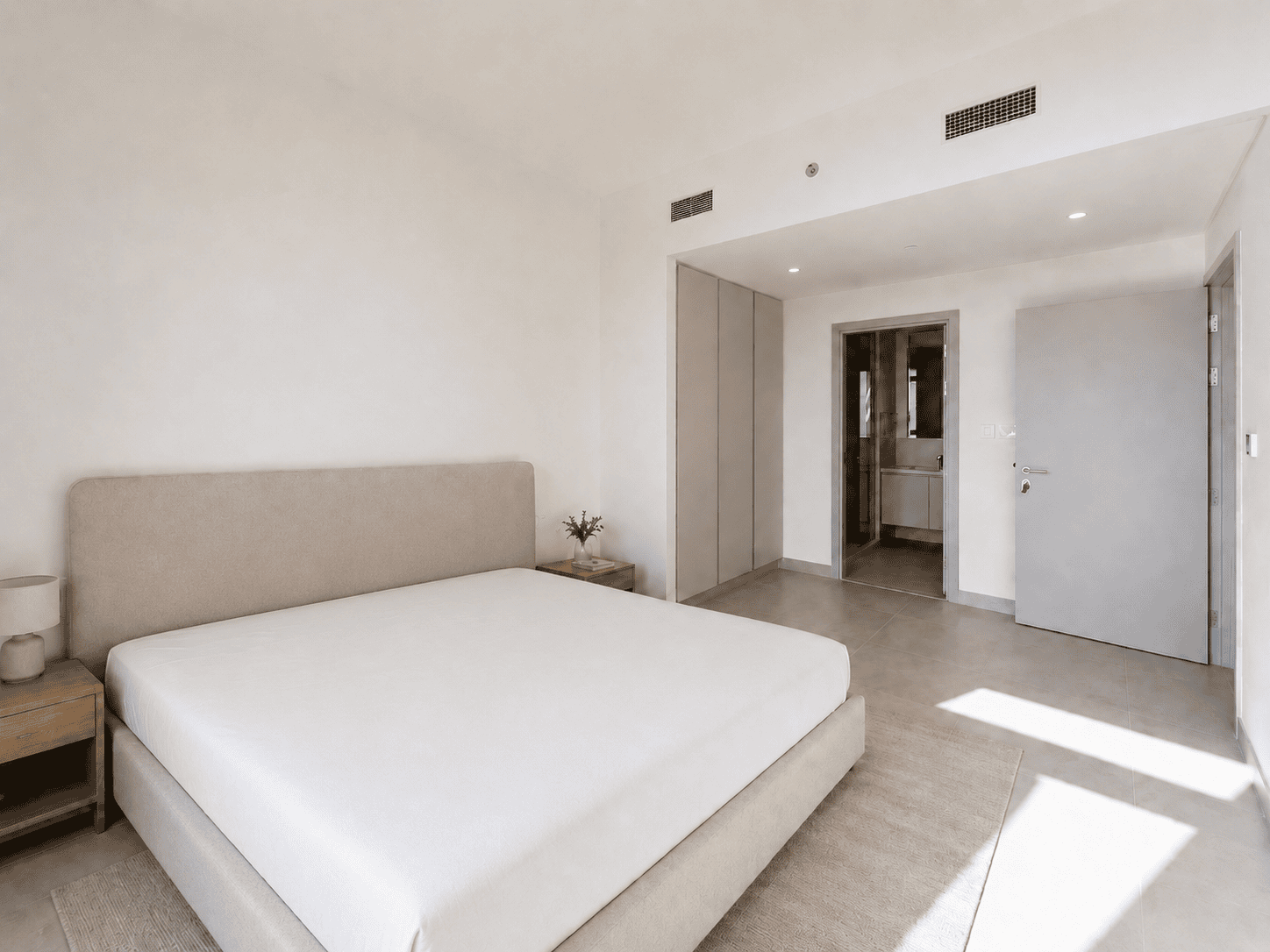 Bedroom renovation with upholstered bed, oak nightstands, built-in wardrobes and en-suite bathroom in Creek Harbour