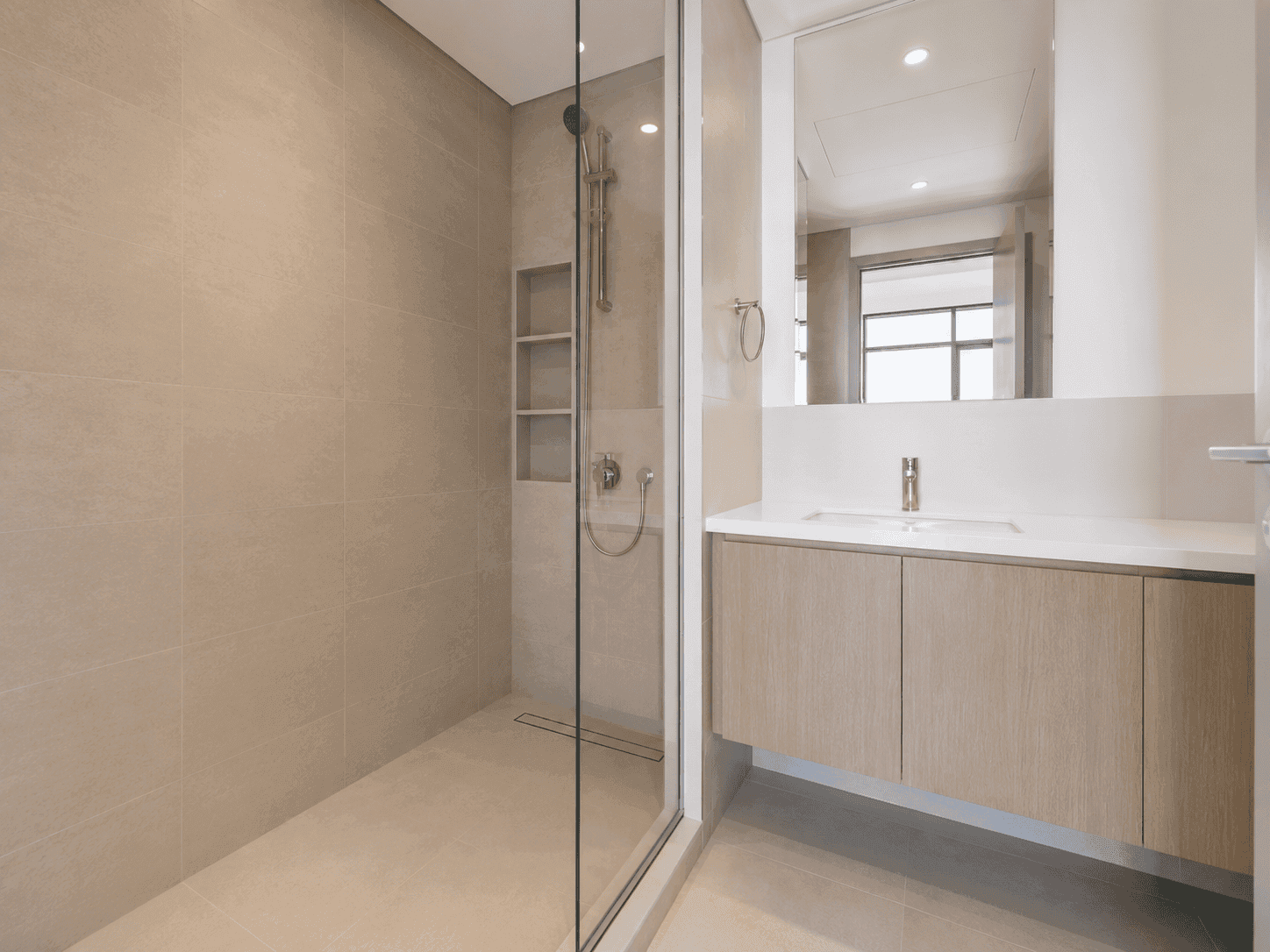 Bathroom renovation with frameless walk-in shower, recessed niche shelves and floating oak vanity in Dubai Creek Harbour