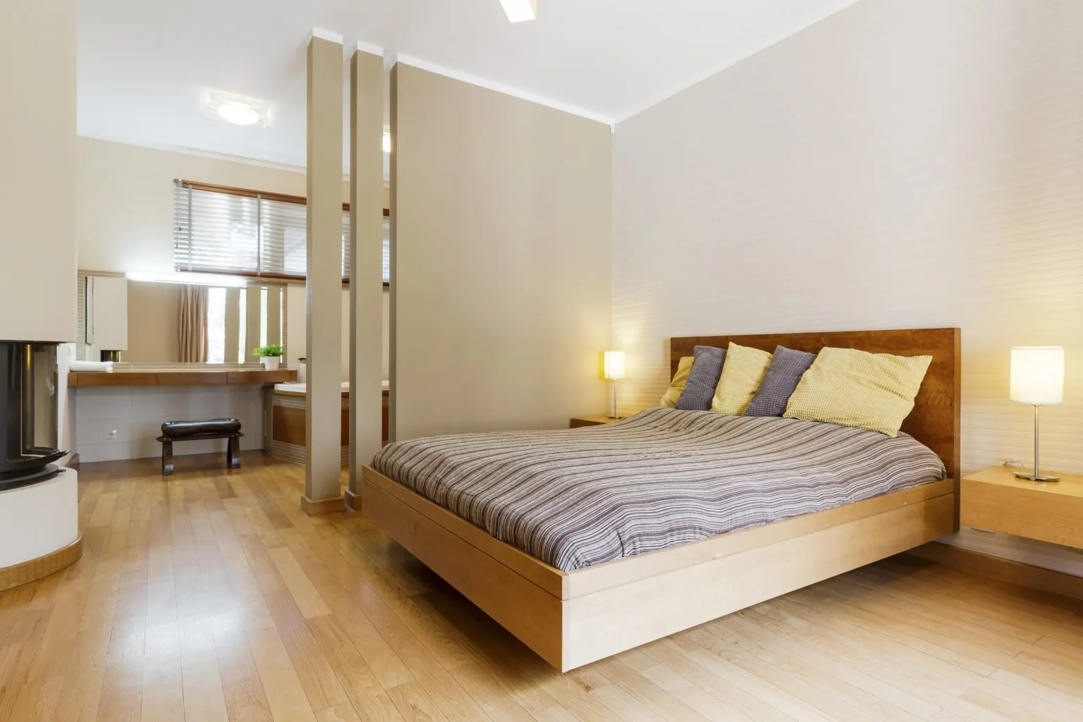 Master bedroom with a floating timber platform bed and a slatted screen to the dressing area
