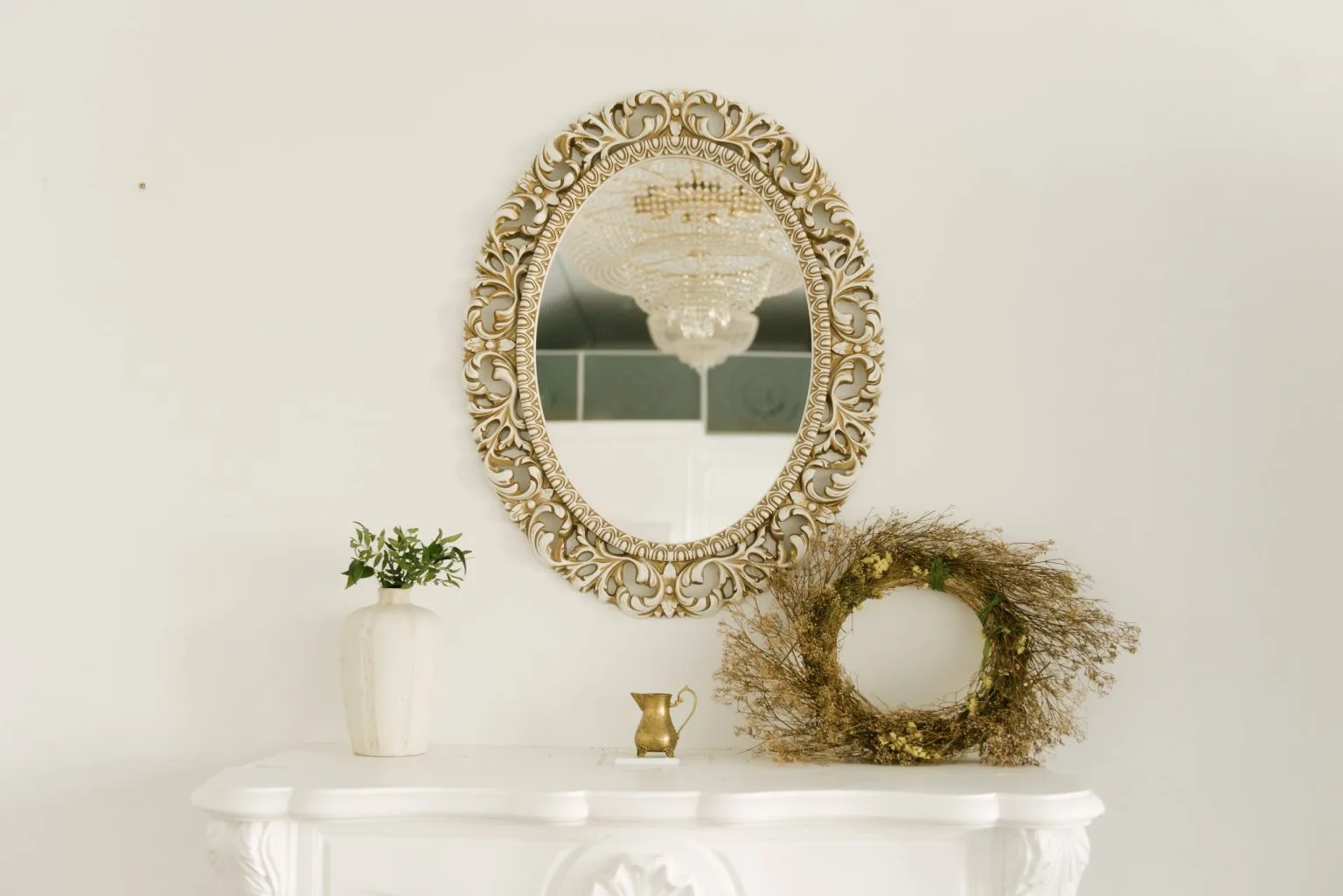 Ornate gold framed oval decorative mirror hung on a Dubai living room wall