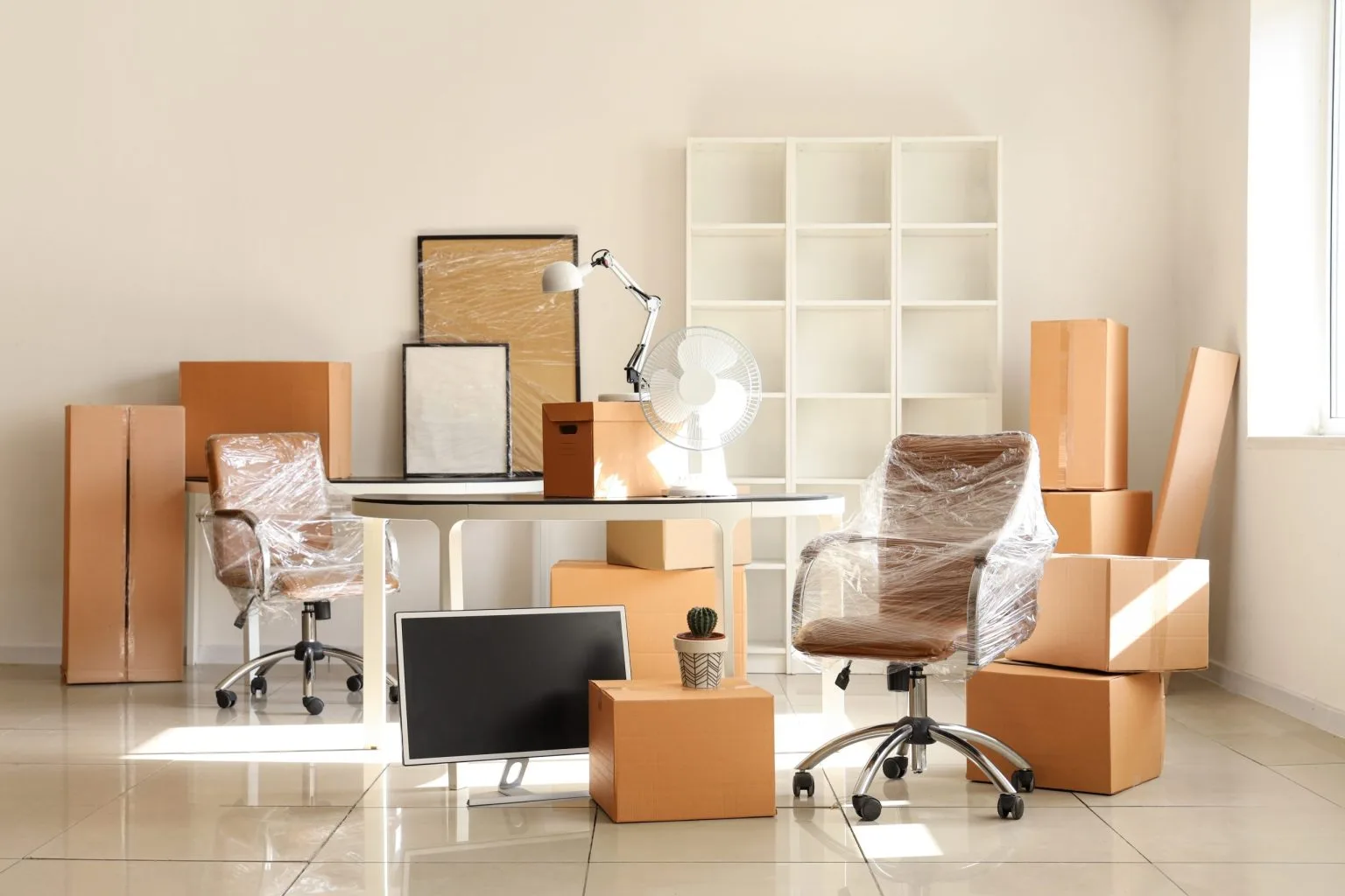 Office chairs and desk wrapped in protective film before dismantling and transport
