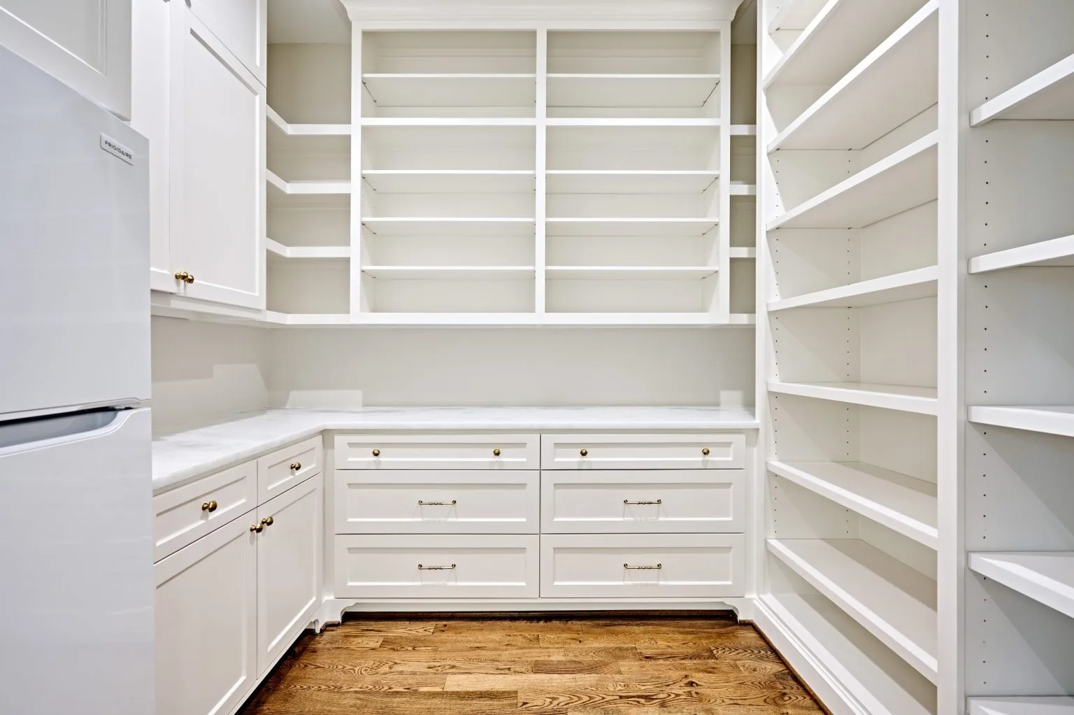 Walk-in butler’s pantry with floor-to-ceiling open shelving and drawer base units