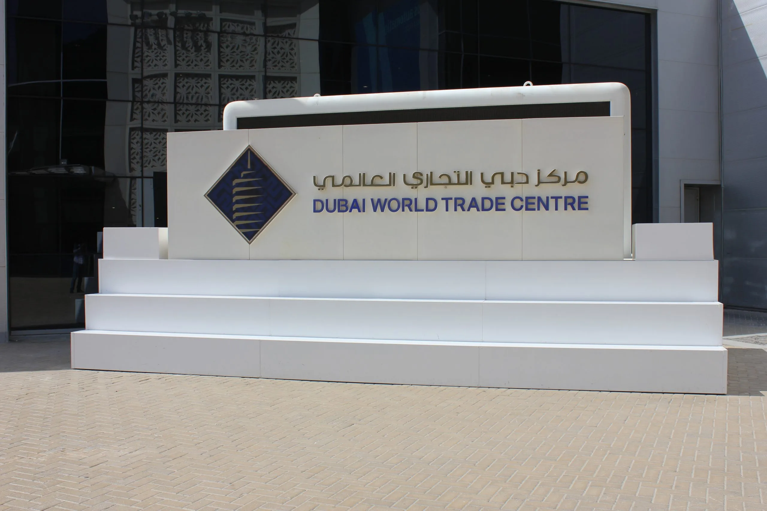 لافتة نصبية لمركز دبي التجاري العالمي بحروف معدنية وشعار على جدار