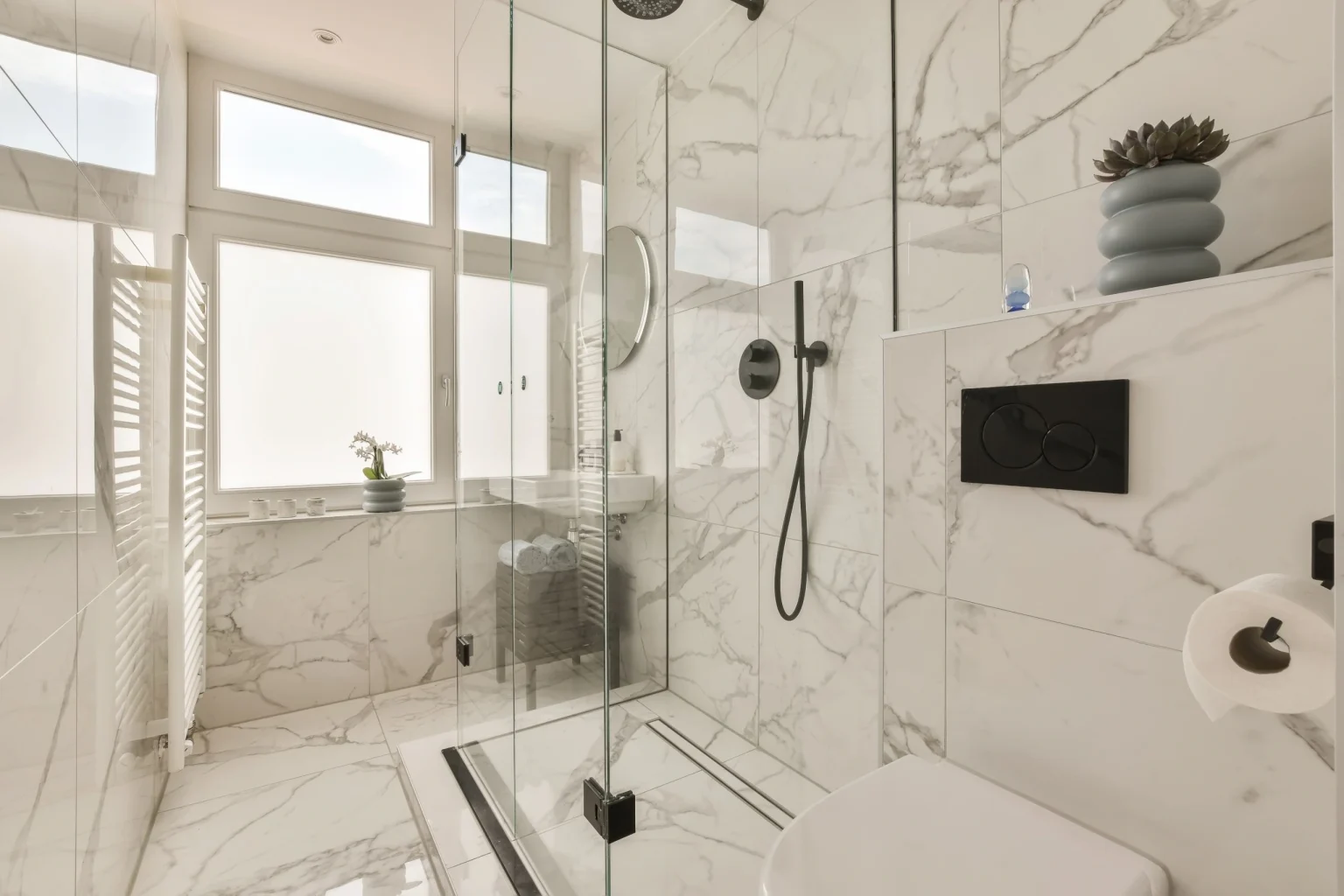 Marble-effect stone shower walls behind a glass screen in a Dubai bathroom