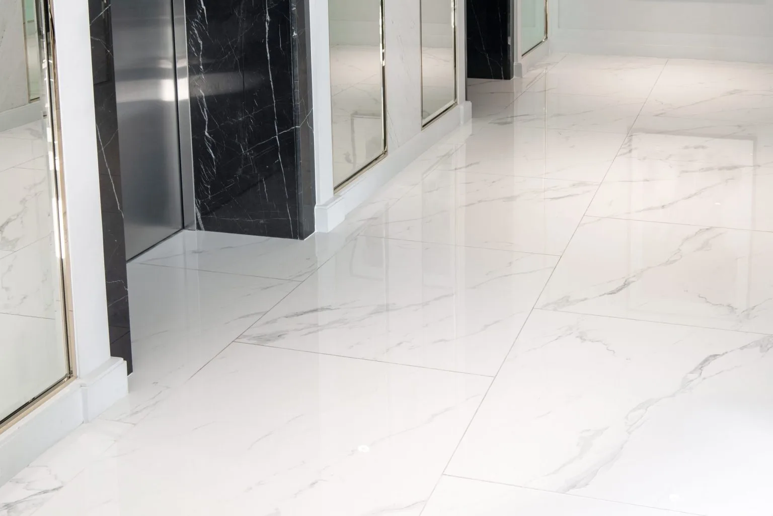 Polished white marble flooring meeting a black marble wall in a Dubai interior