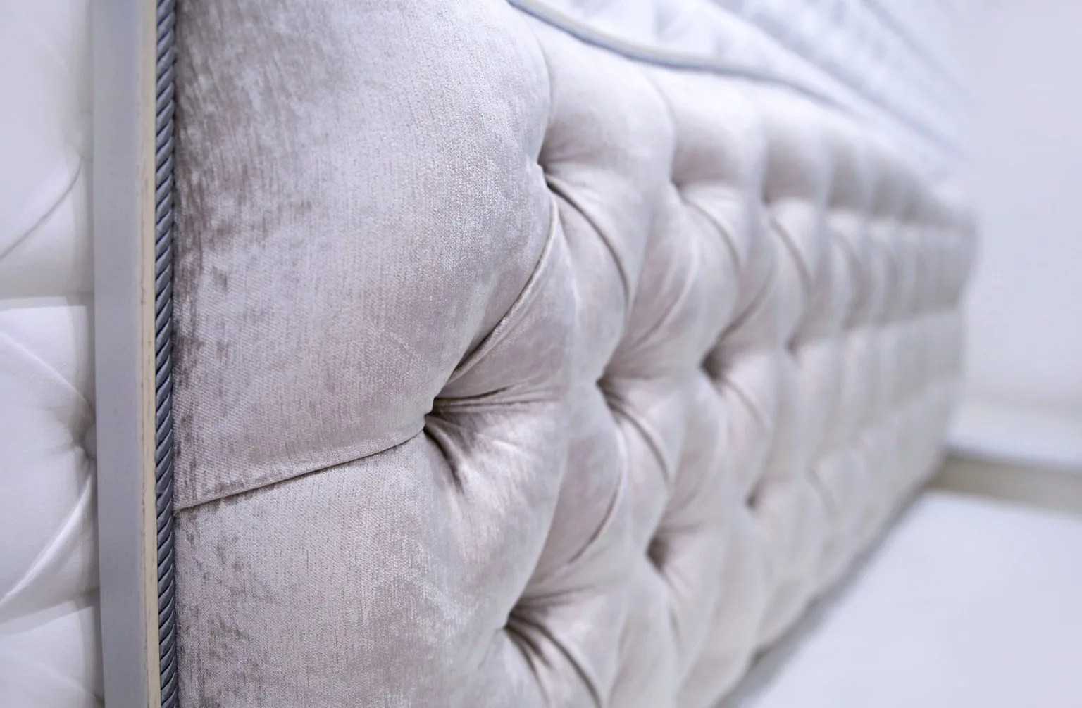 Button-tufted upholstered headboard in pale fabric made in Dubai