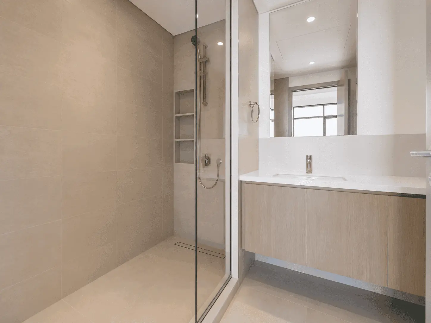 Bathroom renovation with frameless walk-in shower, recessed niche shelves and floating oak vanity in Dubai Creek Harbour