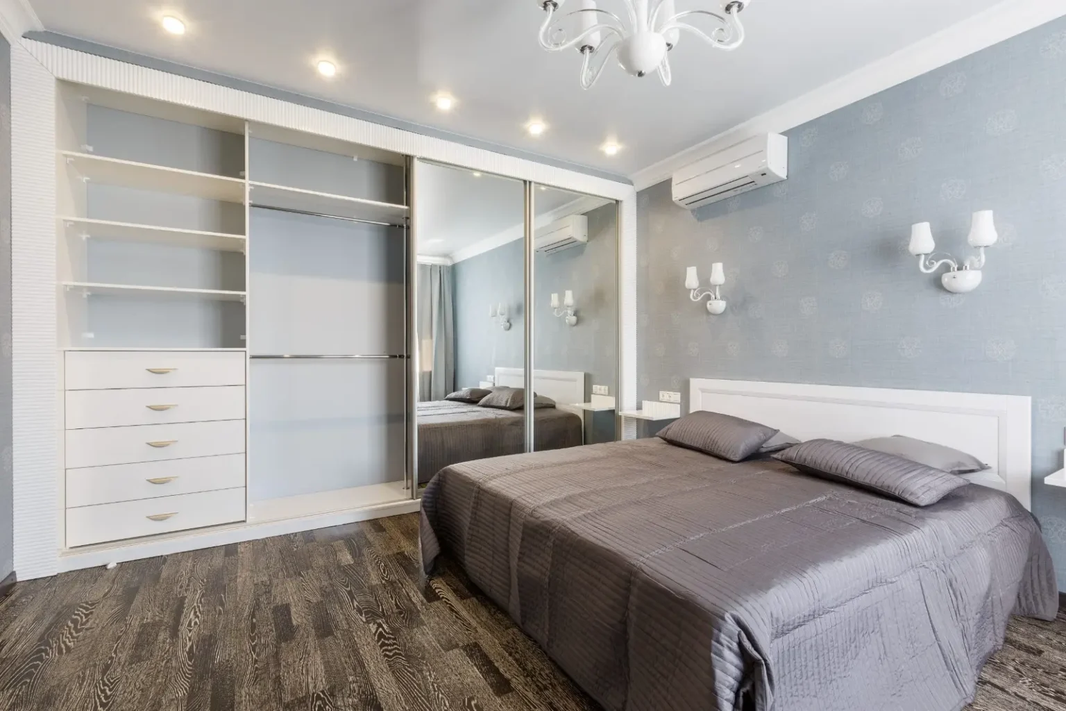 Walk-in closet with open shelving, banked drawers and mirrored sliding doors to the bedroom