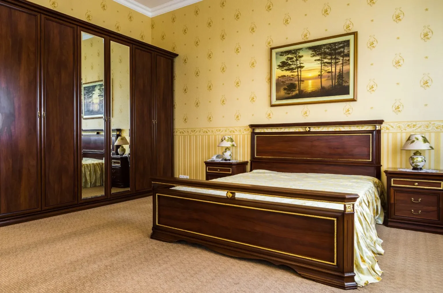 Guest bedroom with a classic timber bedroom set, mirrored wardrobe and patterned wallpaper