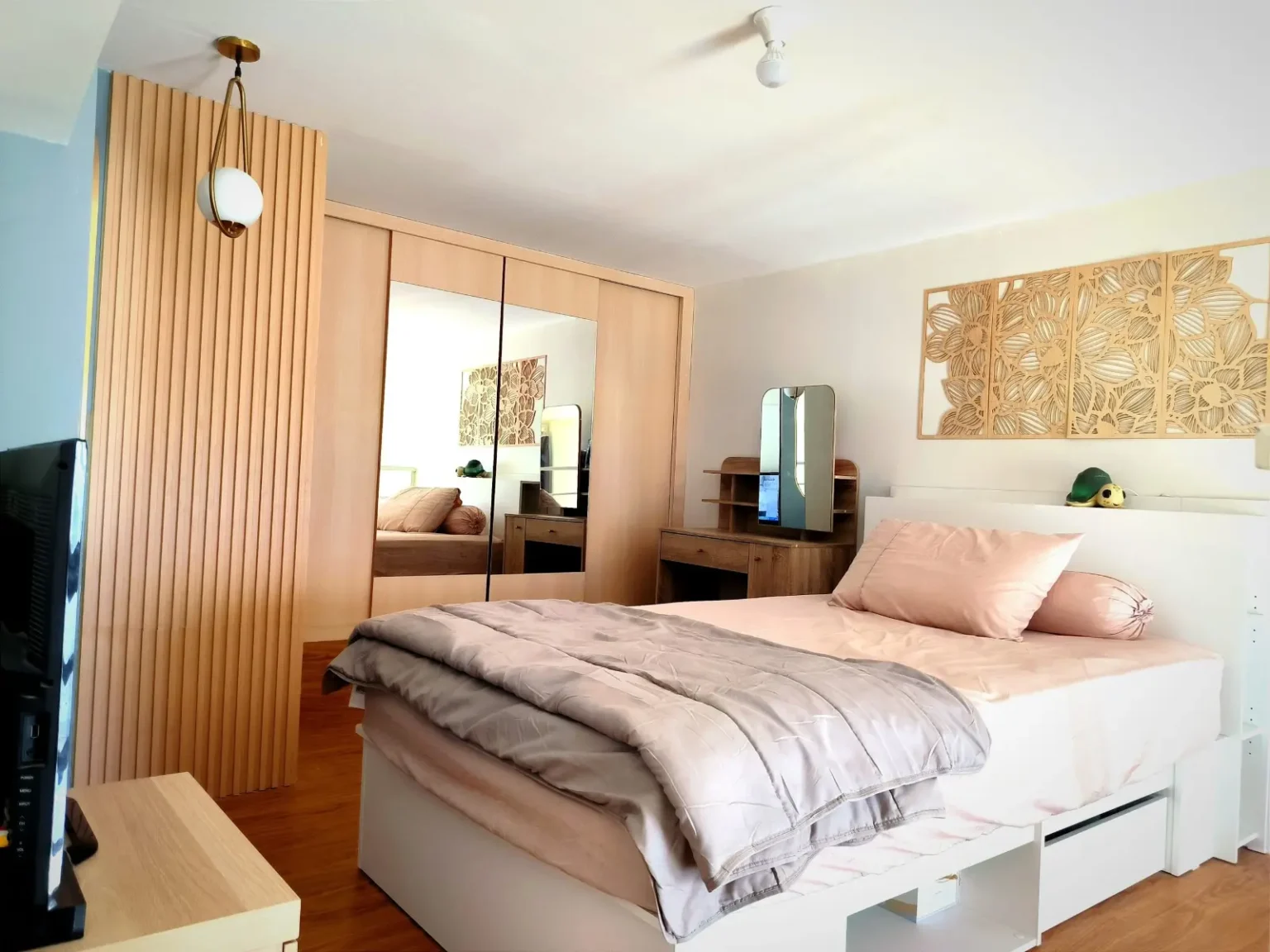 Fluted timber partition and laser-cut decorative panelling dividing a bedroom and dressing area