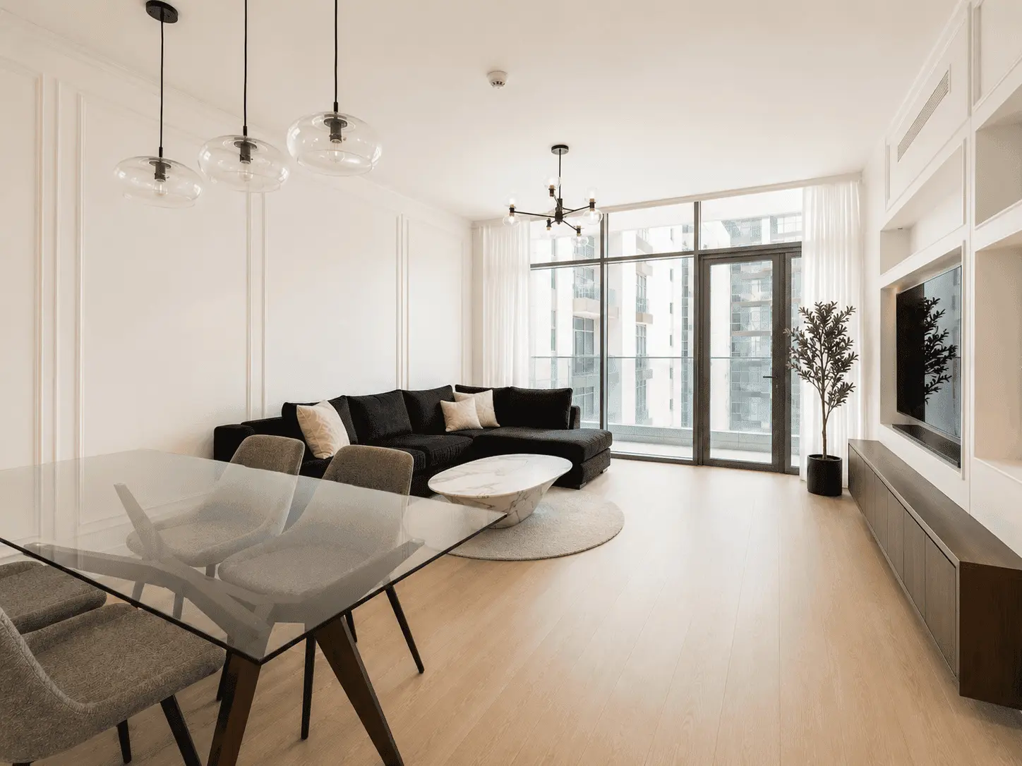 Open-plan living room renovation with glass dining table, pendant lights and balcony access in Park Heights apartment