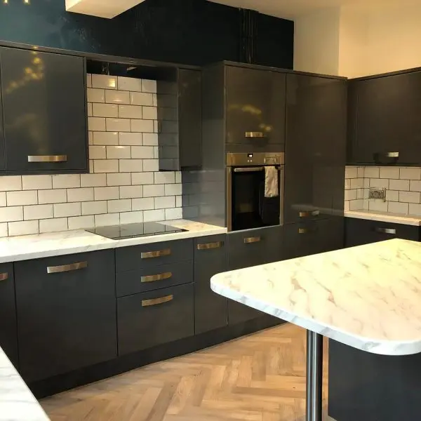 Dark handleless gloss kitchen with marble worktop after renovation by Fitout Renovation Dubai