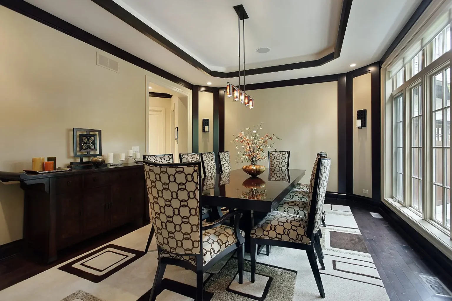 Formal dining room with a recessed tray ceiling, dark timber trim and a long sideboard