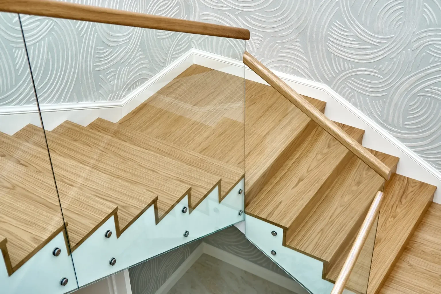 Oak staircase with a frameless glass balustrade assembled by bespoke joinery makers in Dubai