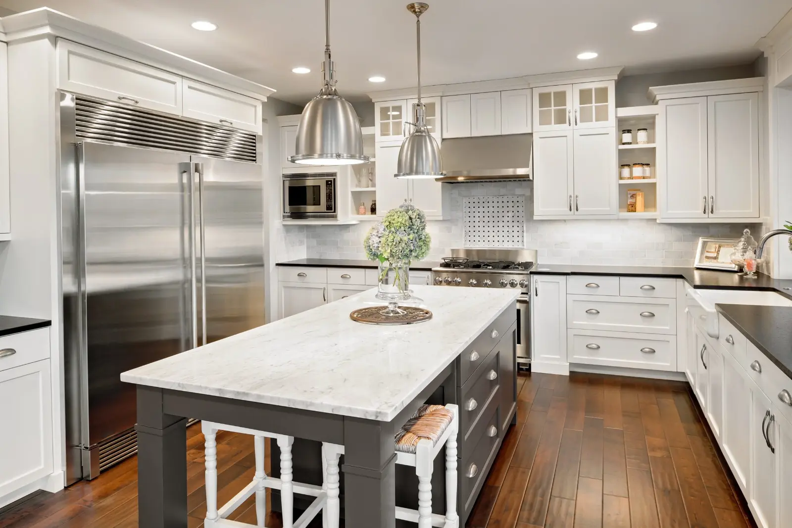 Luxury custom kitchen cabinets Dubai with a grey marble countertop island and built-in appliances