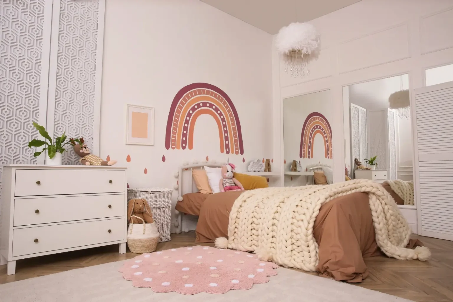 Hand-painted rainbow mural in a Dubai children&rsquo;s room beside plain neutral painted walls
